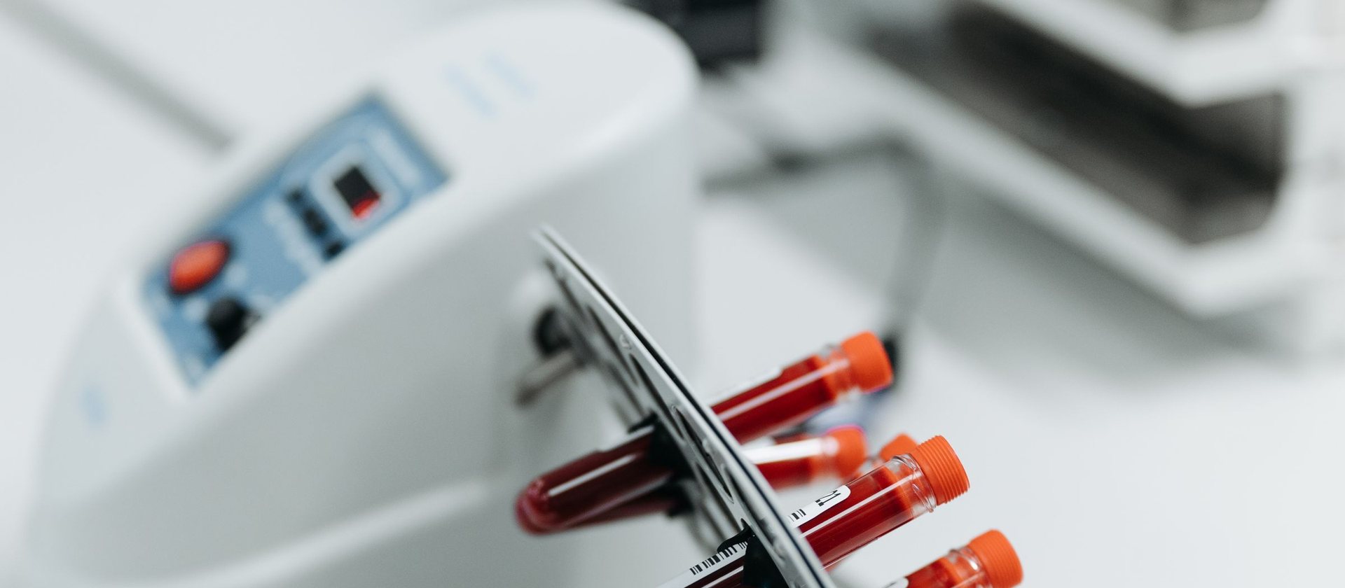 Blood sample tubes resting beside a laboratory analyser