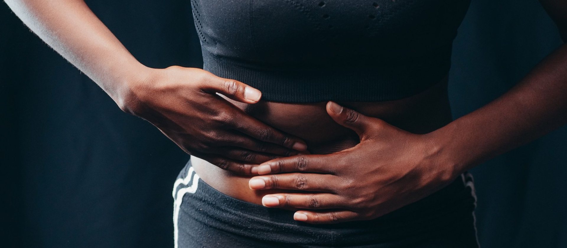 Both hands resting across the upper abdomen