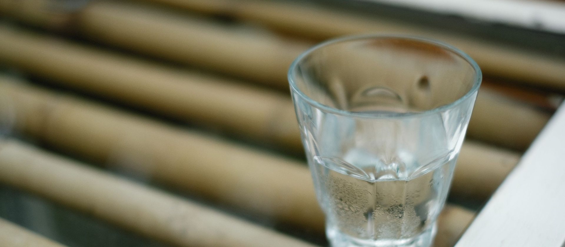 A glass of clear water on a bamboo surface